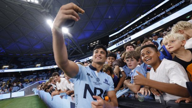 Joseph-Aukuso Suaalii of the Waratahs takes selfies with fans.
