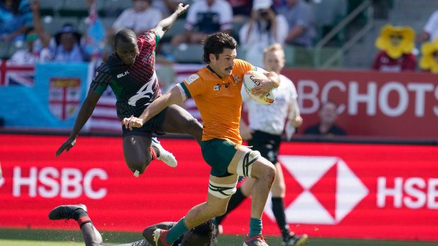 Australia's Henry Paterson evades the Kenyan defence to score a try.