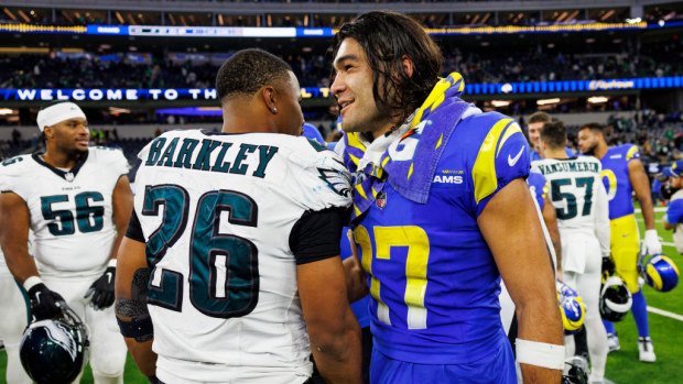 Running back Saquon Barkley #26 of the Philadelphia Eagles and wide receiver Puka Nacua #17 of the Los Angeles Rams interact.