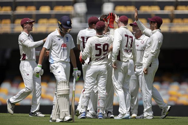 A dejected Sam Konstas of New South Wales leaves the field as Queensland celebrate his wicket.