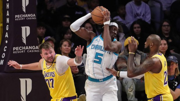 Mark Williams (5) of Charlotte Hornets grabs a rebound against LeBron James (23) and Luka Doncic (77).