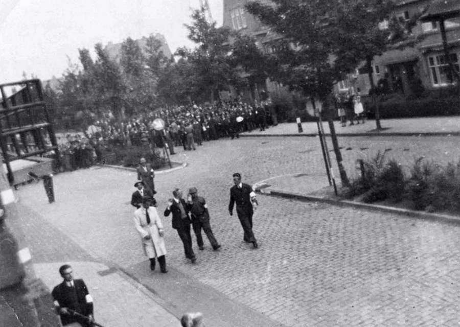 Ad van Eerd (2-R of group of four men) walks beside Adrianus Wolterbeek after his arrest by P.A.N. Ad van Eerd (2-R of group of four men) walks beside Adrianus Wolterbeek after his arrest by P.A.N.