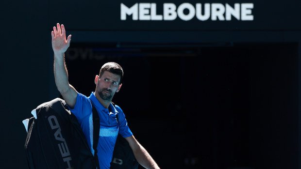 Novak Djokovic of Serbia acknowledges the crowd as he leaves the court after retiring.