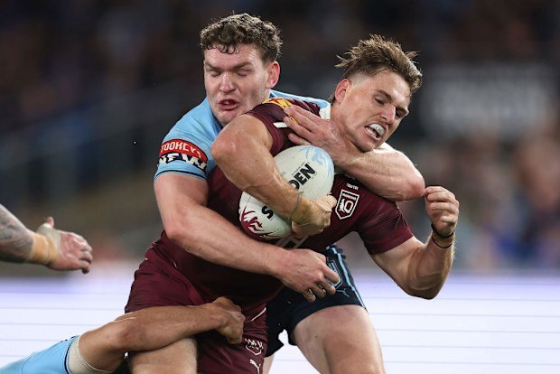 AJ Brimson of the Maroons is tackled by Liam Martin of the Blues.