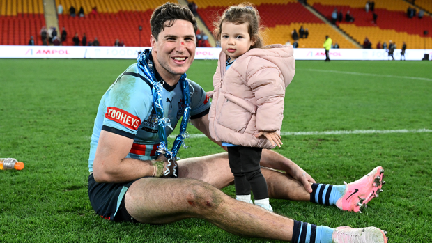 A battered and bruised Mitchell Moses celebrates his daughter Aspyn.