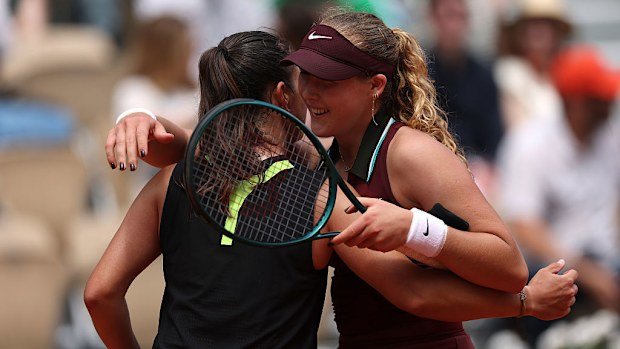 Mirra Andreeva beams as she shares a moment with Daria Kasatkina at the net.