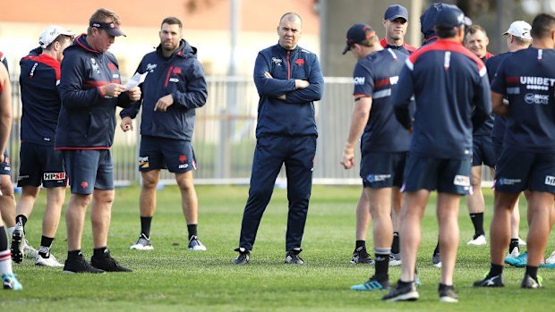 Michael Cheika watches as Roosters coach Trent Robinson provides instructions.
