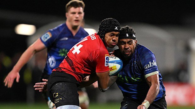 Chay Fihaki of the Crusaders is tackled by Hoskins Sotutu of the Blues.