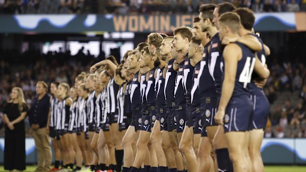 Victoria players and Collingwood AFLW players in line for the national anthem during the 2020 State of Origin for Bushfire Relief match between Victoria and The Allies at Marvel Stadium.