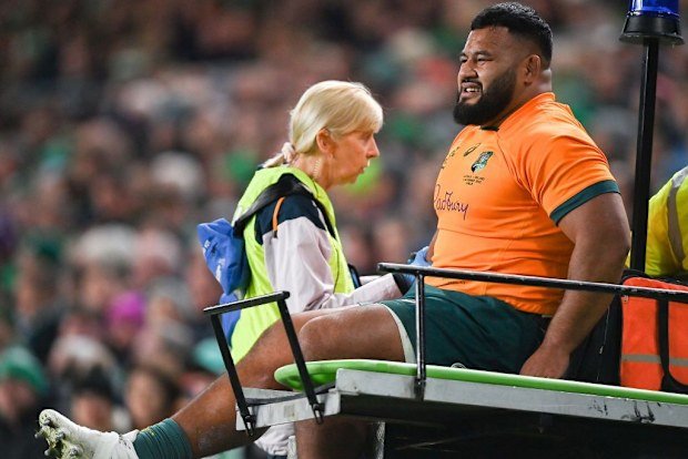 Taniela Tupou of Australia is taken from the pitch to receive medical attention.