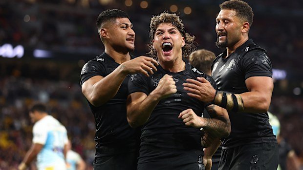 Reece Walsh celebrates scoring a try against the Titans.