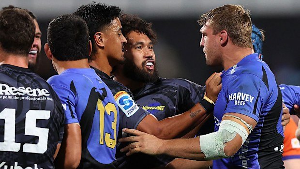 Nick Champion de Crespigny of the Force engages with Hurricanes players.