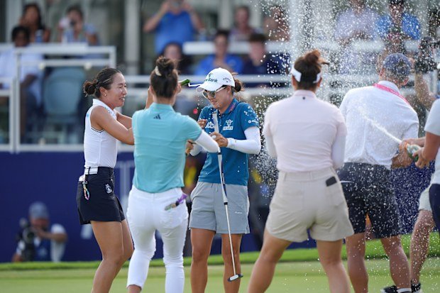 Fellow players rush to congratulate Minjee Lee on the 18th green after she won the women's PGA Championship.