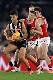 Nick Daicos of the Magpies is tackled by Marcus Windhager of the Saints.