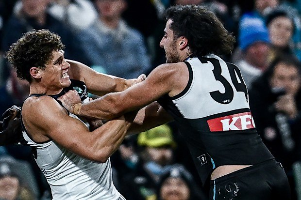 Charlie Curnow of the Blues clashes with Lachie Jones of the Power.