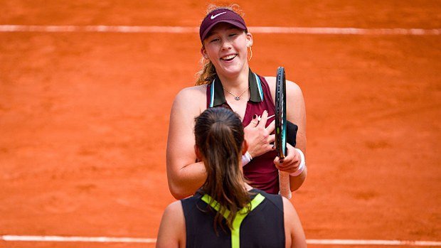 Mirra Andreeva holding Daria Kasatkina's wristband after her victory.
