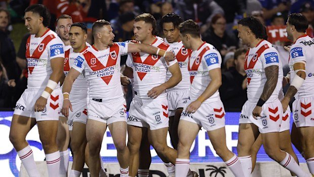 Nathan Lawson of the Dragons celebrating after scoring a try with his teammates.