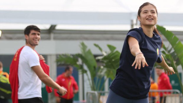 Carlos Alcaraz of Spain interacts as Emma Raducanu of Great Britain warms up.