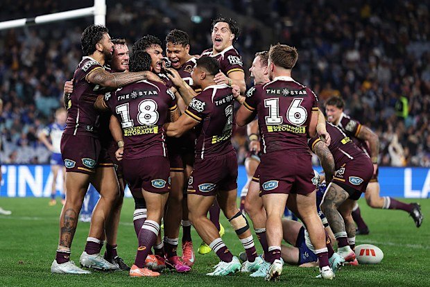 Brendan Piakura of the Broncos celebrates scoring a try.