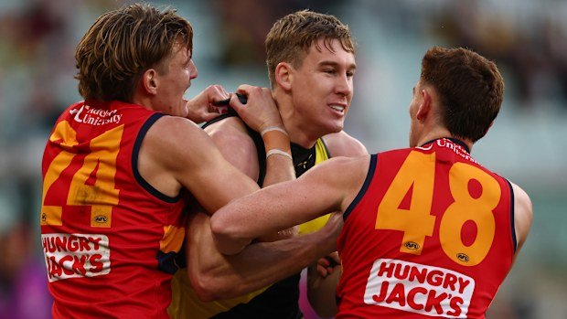 Tom Lynch of the Tigers wrestles with Josh Worrell and Mark Keane of the Crows.