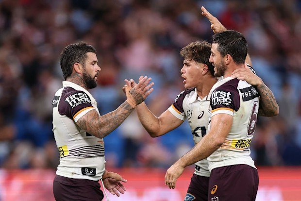 Adam Reynolds, Ben Hunt and Reece Walsh of the Broncos celebrate winning the round one NRL match against the Sydney Roosters.